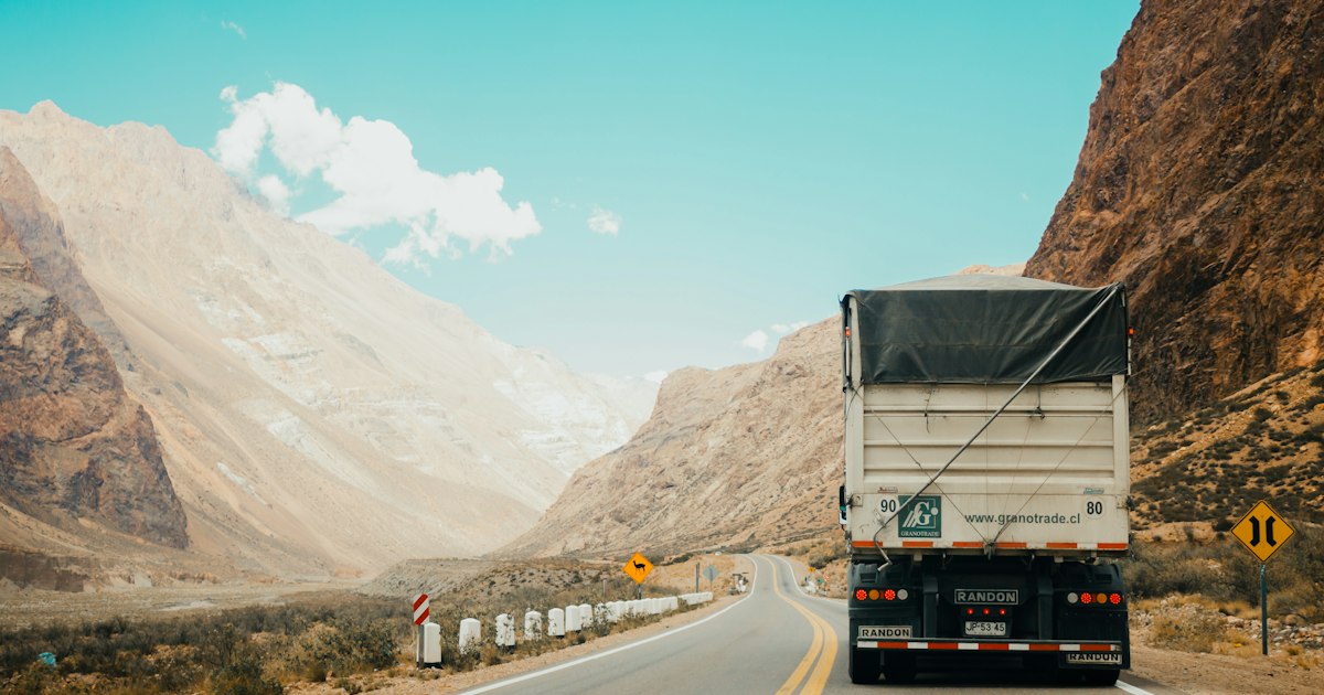 Caminhão de carga pesada transportando equipamento em estrada ao entardecer